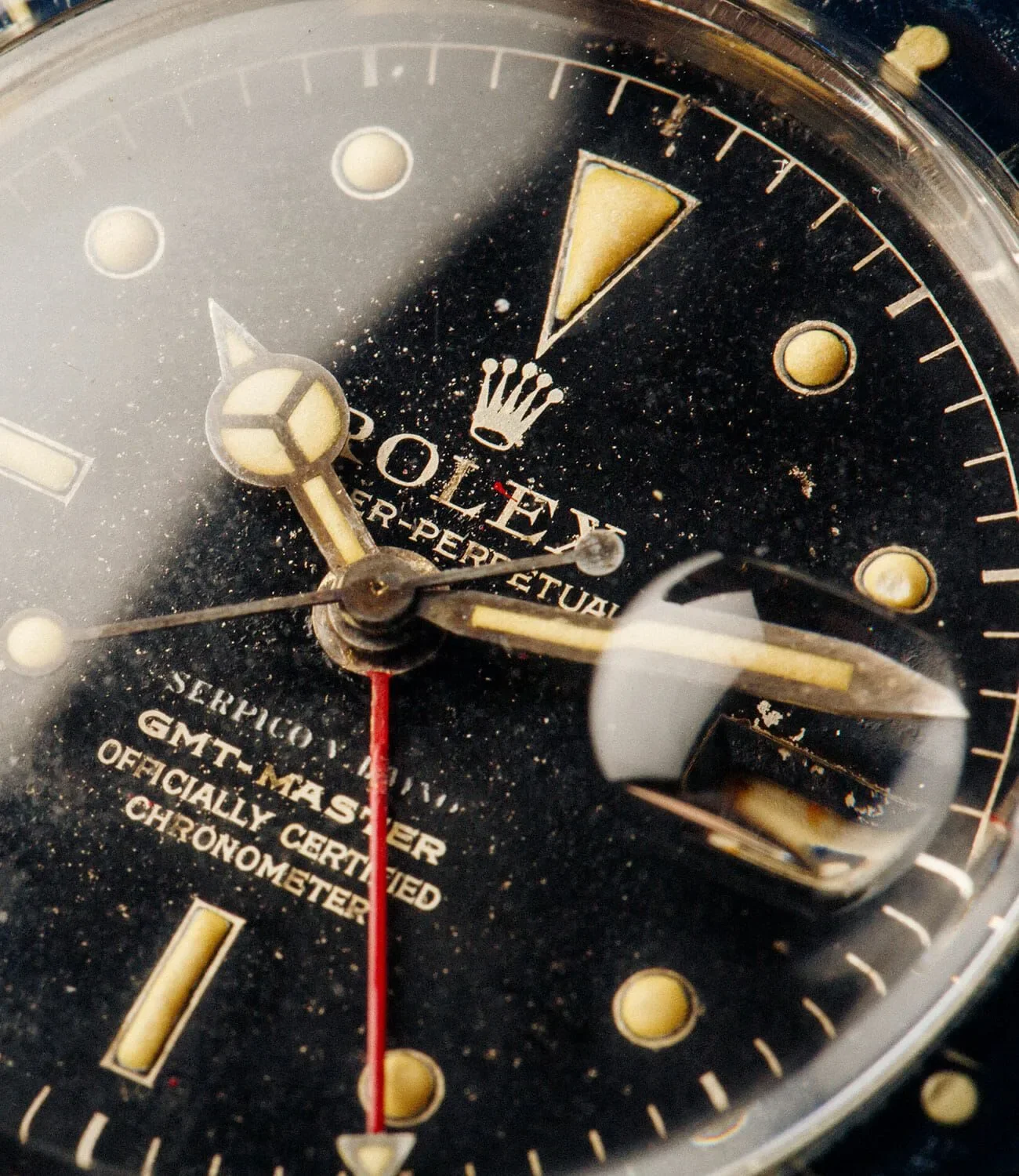 Reloj de pulsera Rolex con esfera negra y detalles dorados, mostrando la fecha y en estado usado.