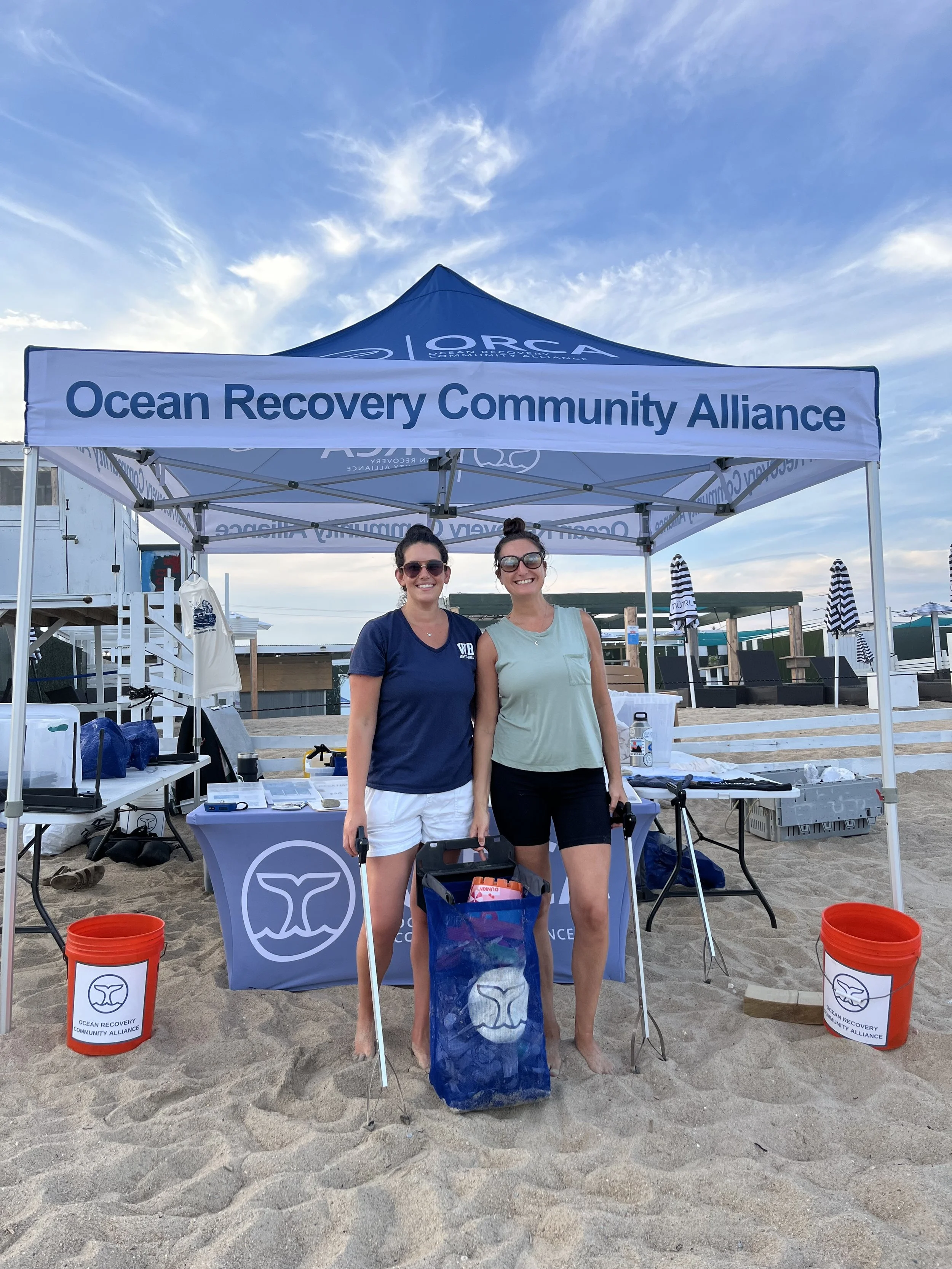 ORCA volunteers posing in front of a beach outreach tent on Misquamicut Beach