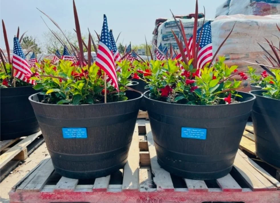 Decorative flower planters along Atlantic Avenue in Misquamicut with American flags and coastal landscaping