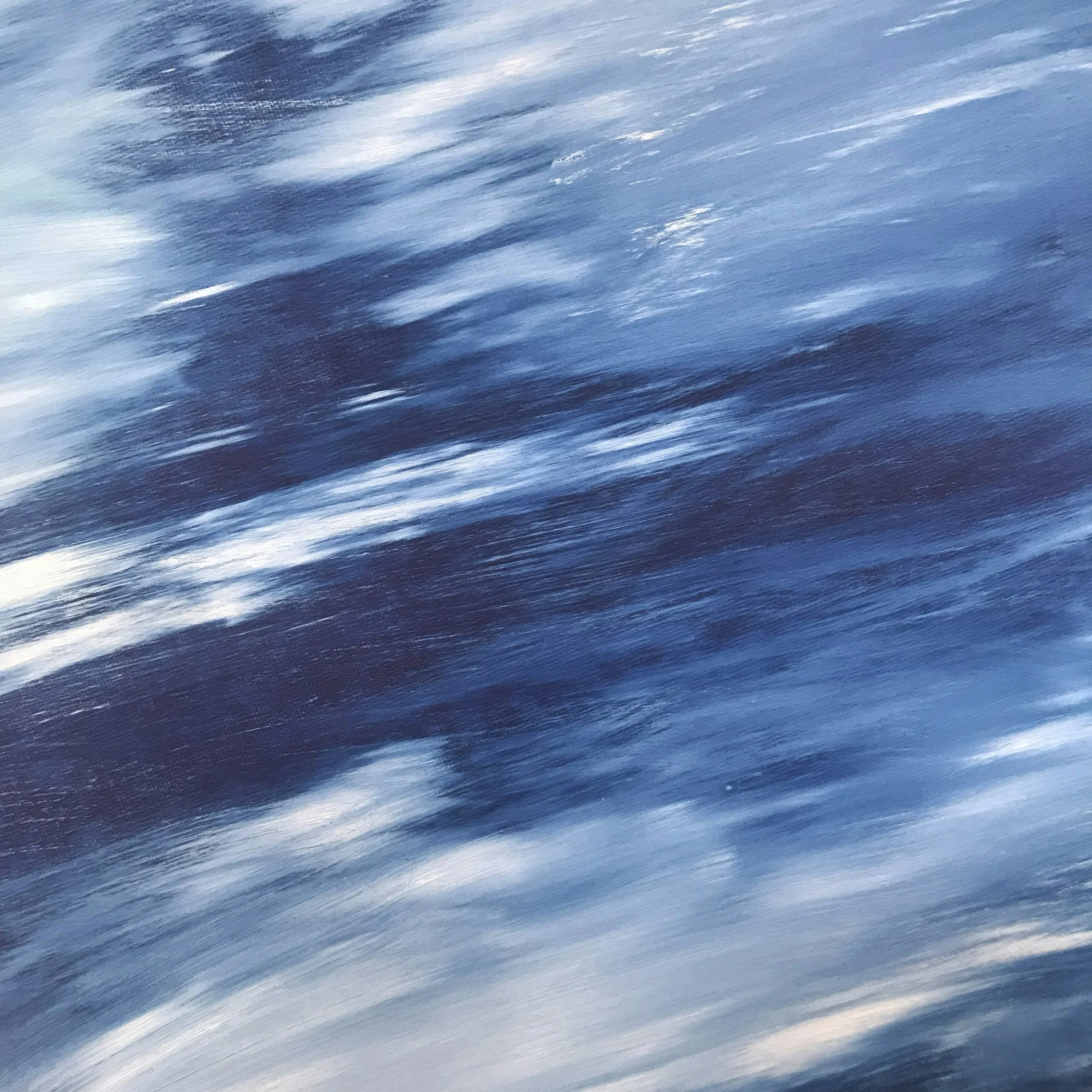 Blurred motion photo of water with blue and white streaks.