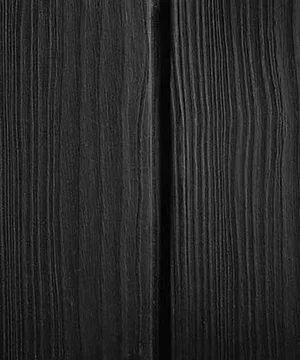 Close-up of black wooden surface with visible grain and texture.