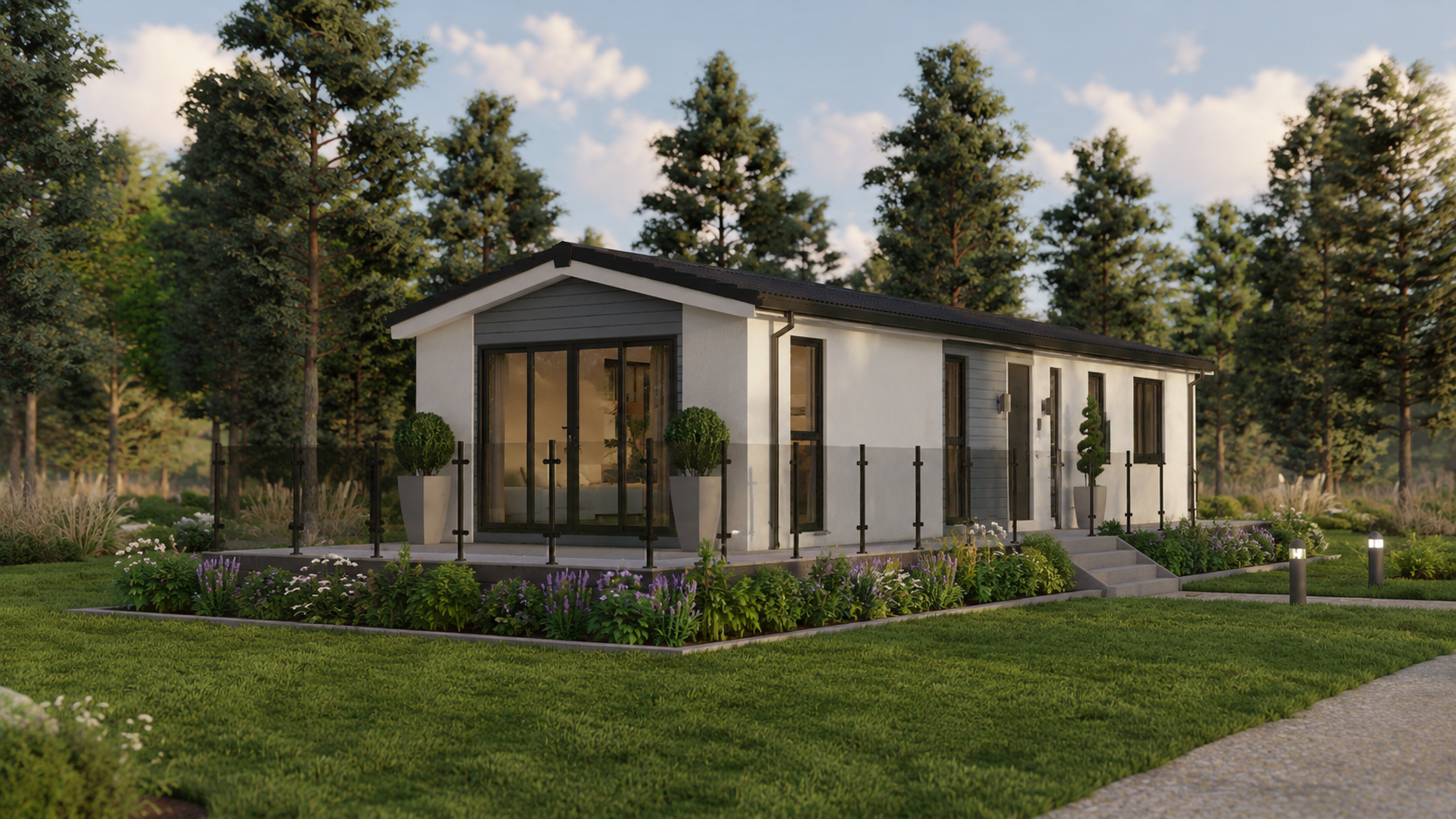 A modern, small house with white exterior walls, black framing, and a black roof situated in a lush green backyard with a garden, trees, and pathway lighting.
