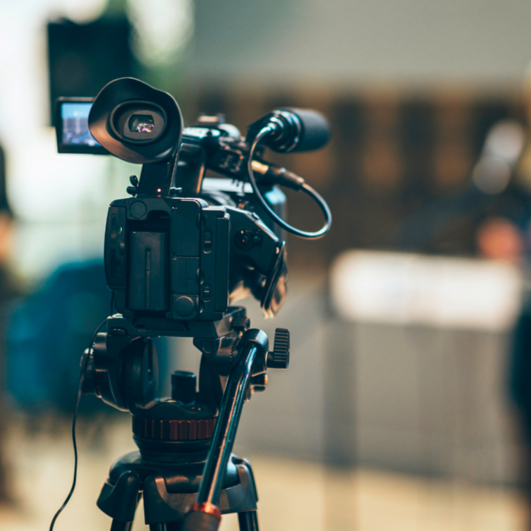 Professional video camera on a tripod in a recording studio or media room.