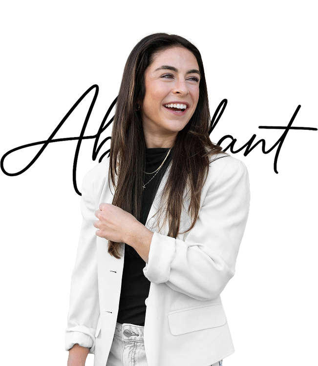 Young woman with long brown hair smiling, wearing a white blazer over a black top and standing against a transparent background.