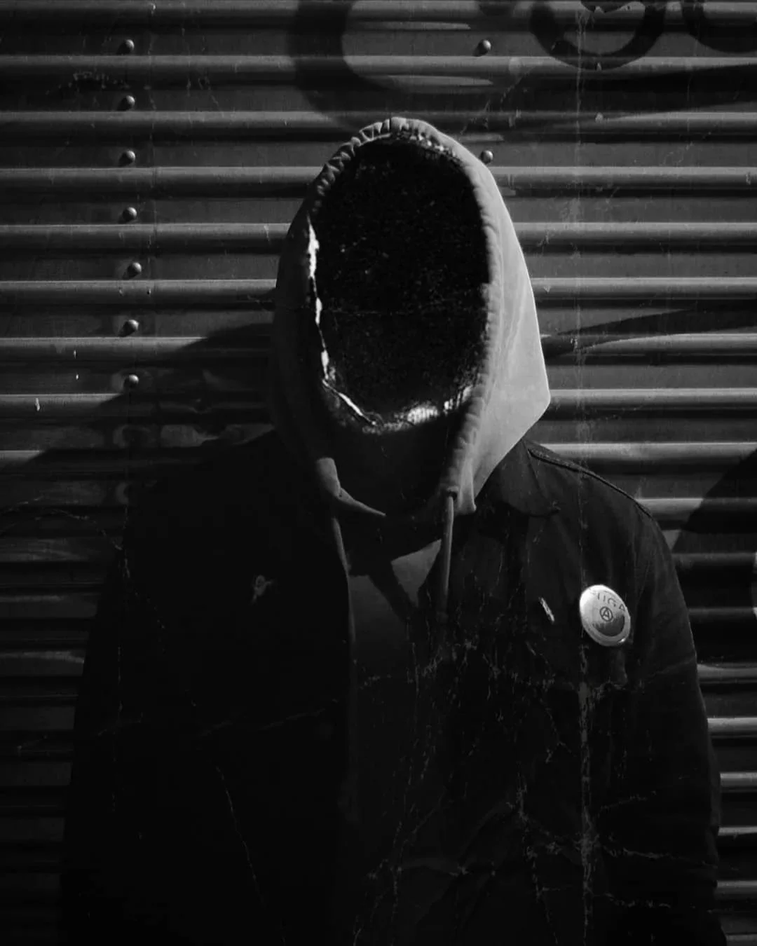 retrato en blanco y negro, surrealista, pin punk, chaqueta negra, chamarra negra, valla metálica, sudadera, surrealismo, dark foto, sin rostro, miedo, desconocido