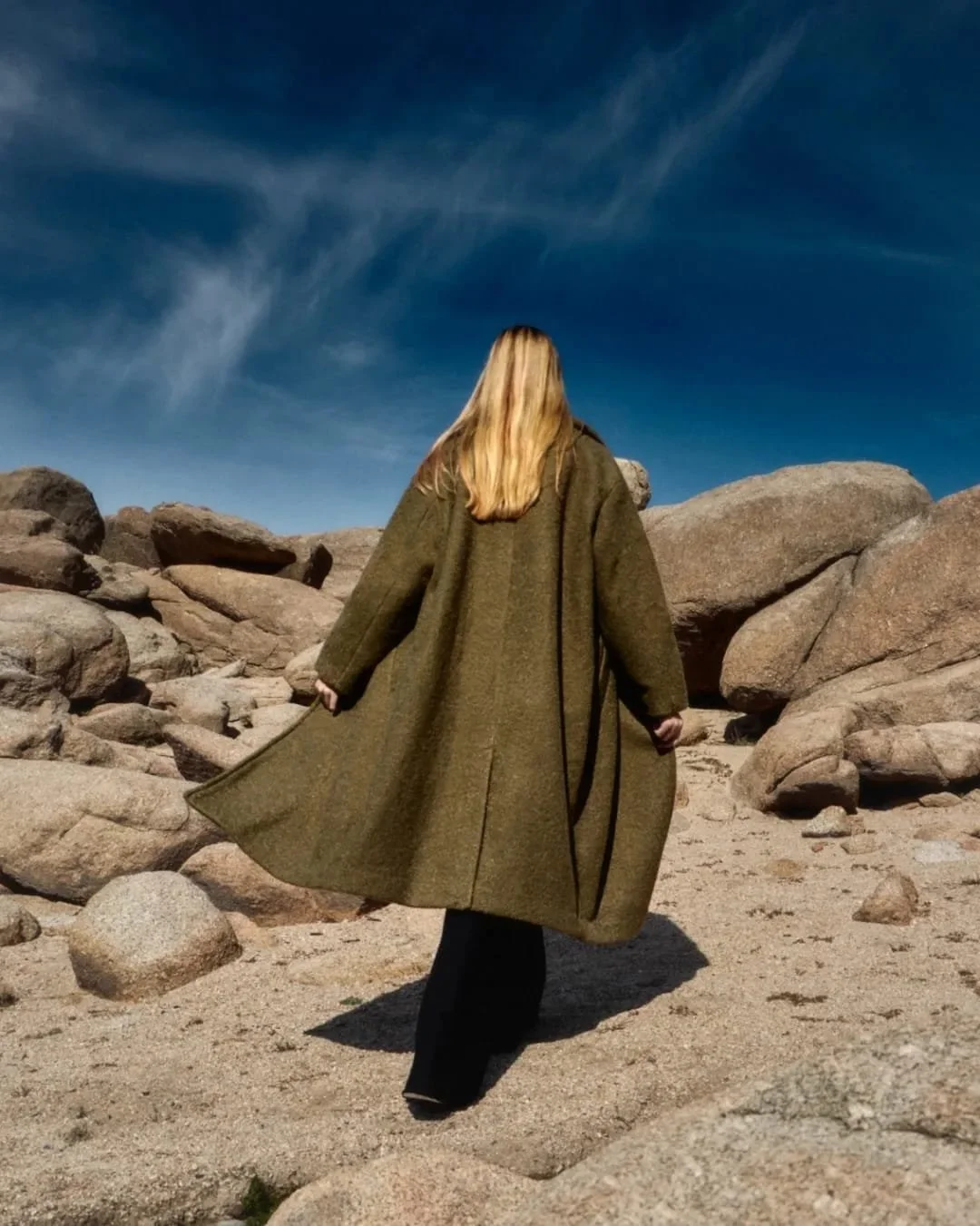retrato moda, editorial, chica rubia, espalda gabardina verde, rocas, moda, cielo azul, nubes, fashion, foto artística, pelo rubio, cabello largo, misterio, soledad, madrid, elegante, otoño