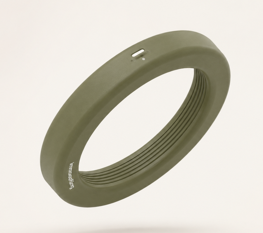 An olive green ImmunoRing device with small holes and ribbed interior, labeled "ImmunoRing