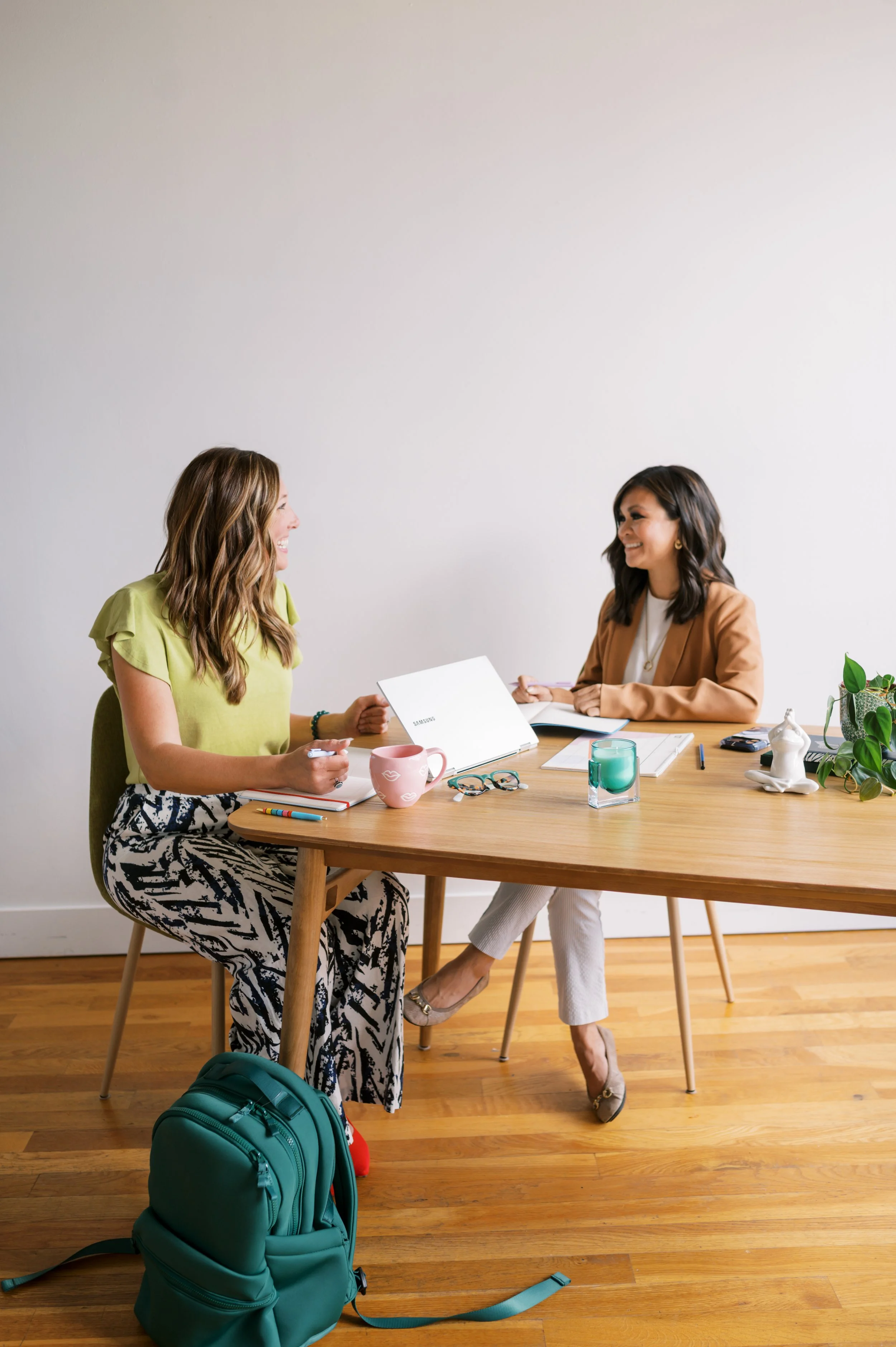 Two women at a table discussing business strategy