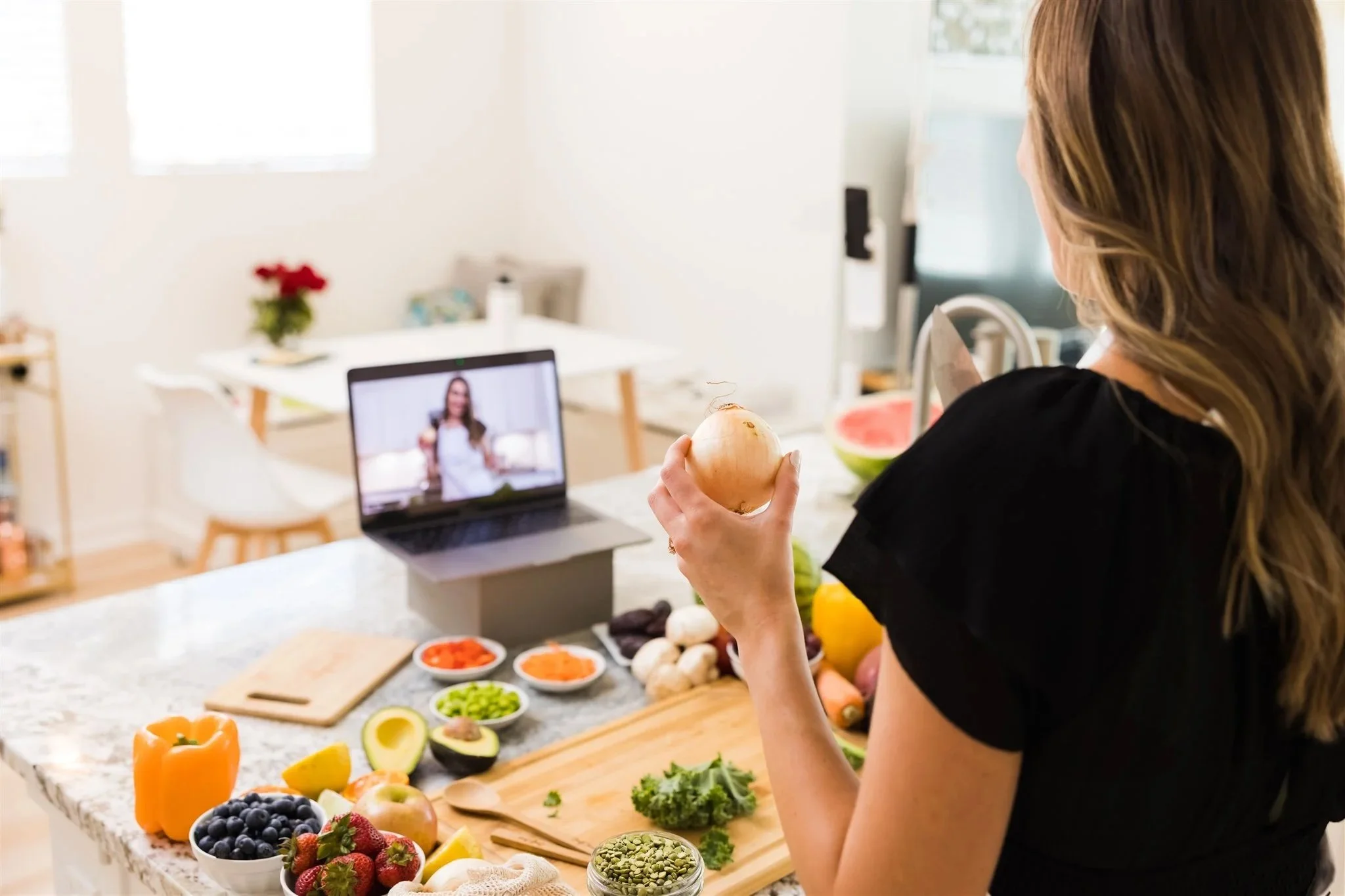 Client participating in a virtual nutrition coaching session while preparing healthy food at home