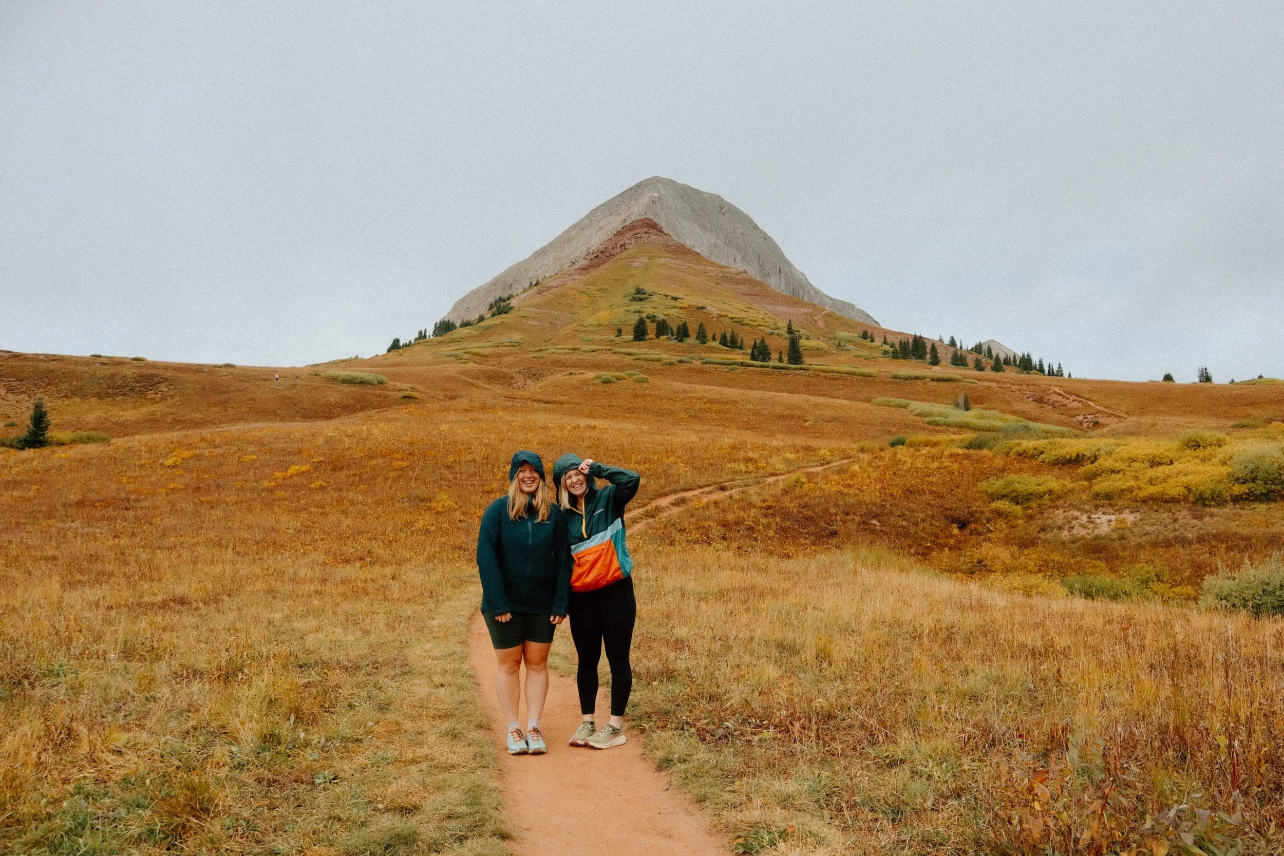 Alison and Laura posing playfully in front Engineer Mountain in Durango, Colorado.