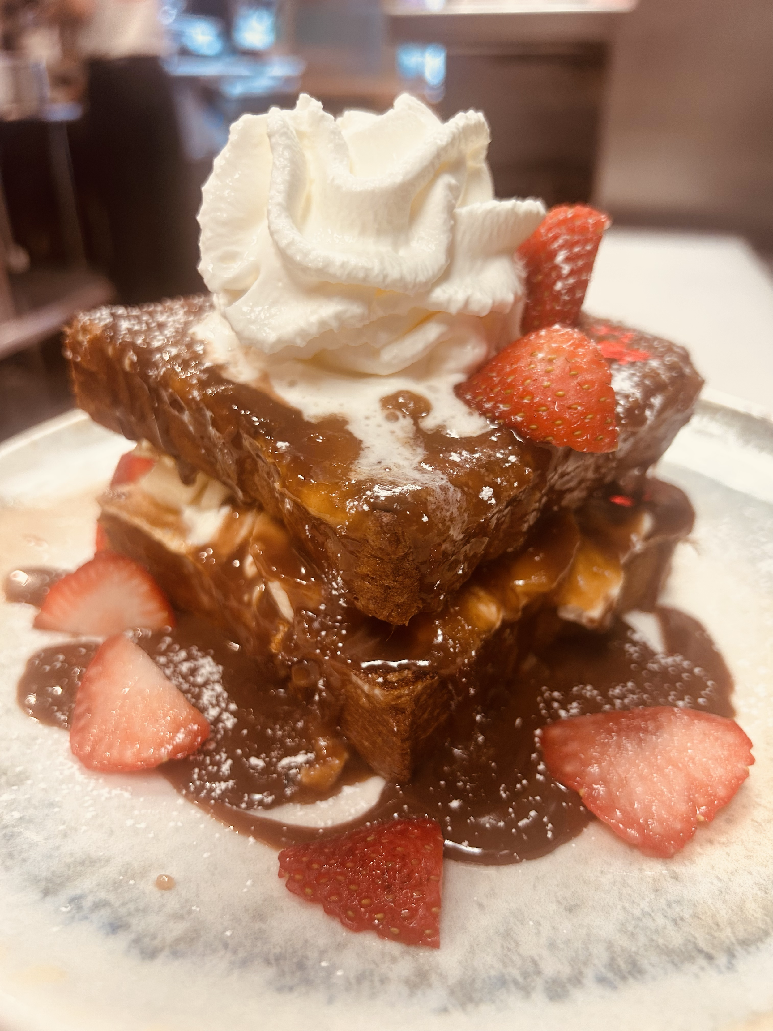 French toast with whipped cream, strawberries and chocolate