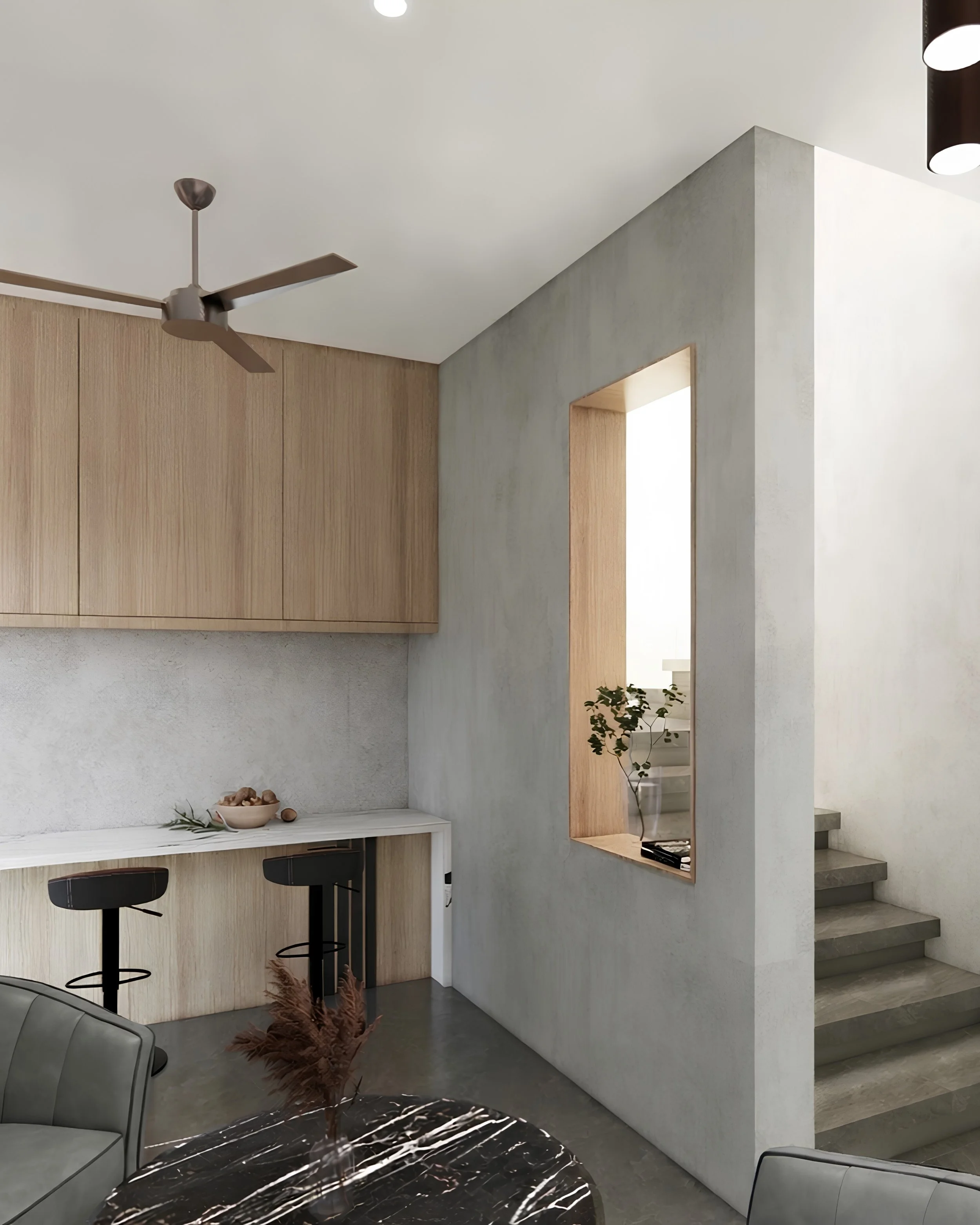 Modern interior kitchen with a white marble round table, black chairs, a wooden cabinetry, a ceiling fan, a concrete and wood partition, and stairs with concrete steps.