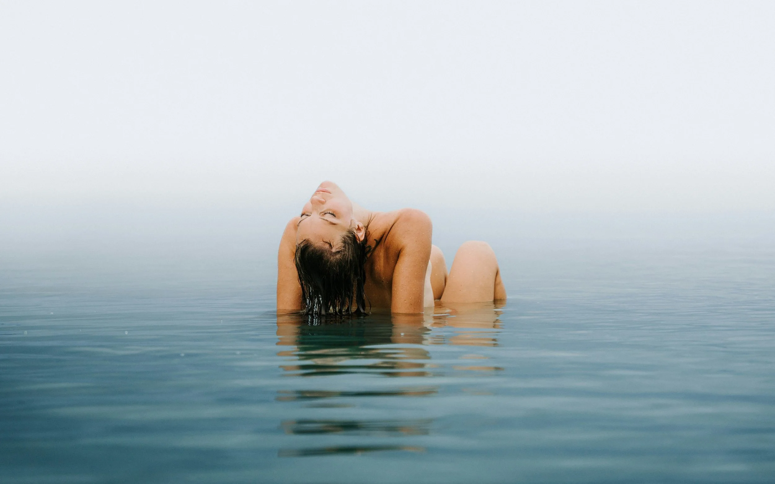 Woman relaxing in calm water with soft natural lighting, evoking freshness and confidence associated with ph balanced feminine wash.
