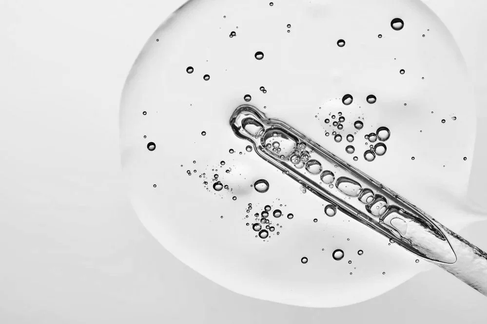 Close-up of clear skincare serum bubbles and dropper texture representing gentle, fragrance free intimate wash ingredients.