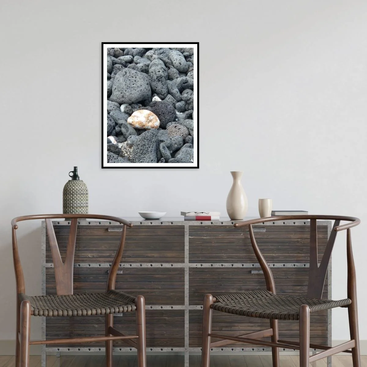 Picture of a collection of lava rocks on a wall in a modern living space with a wooden sideboard and two chairs.