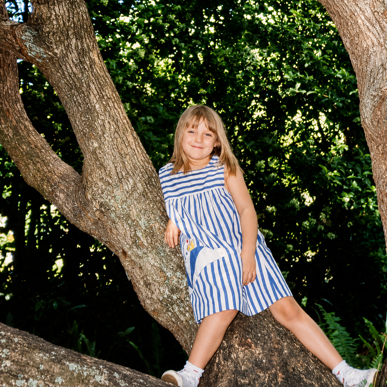 Anna Borrero as a child sitting in a tree, representing her lifelong connection to nature and personal growth.