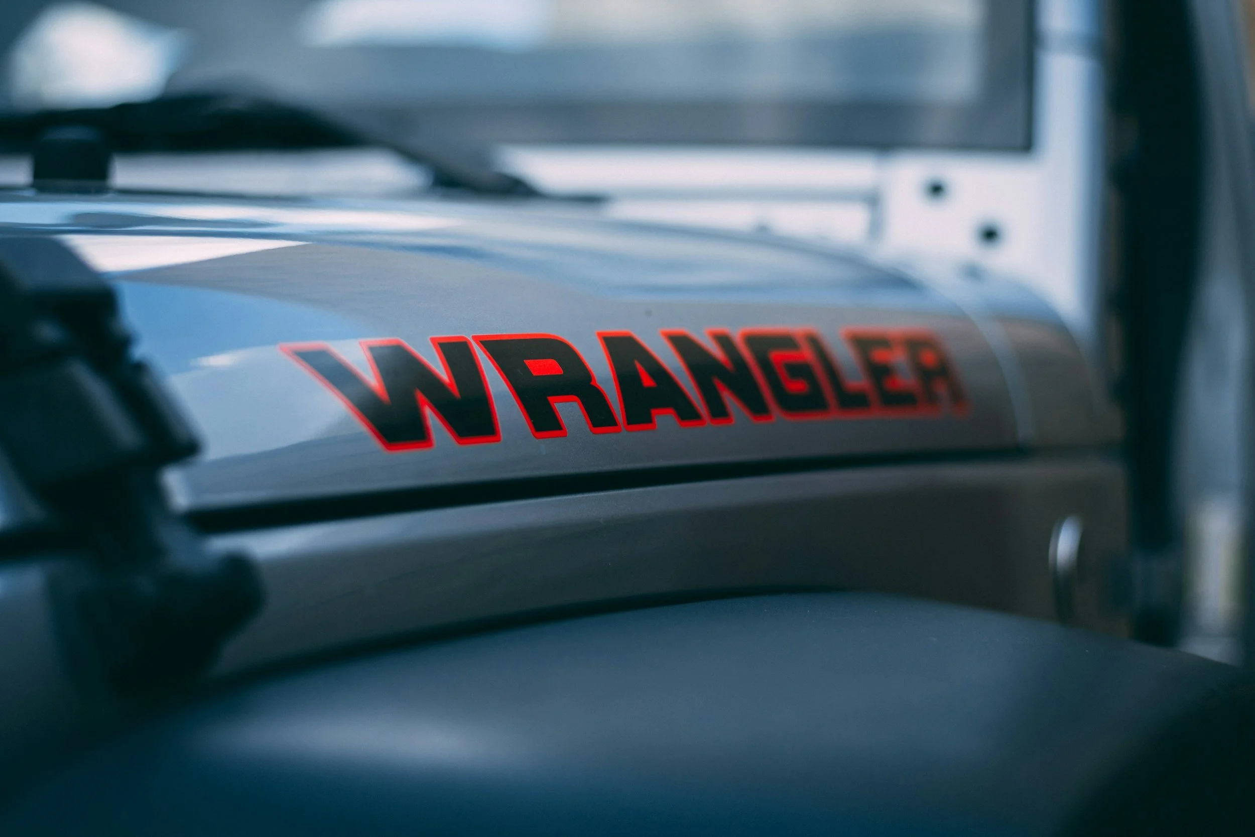Close-up of a metallic surface with a red and black 'WARNING' sticker, with blurred background.