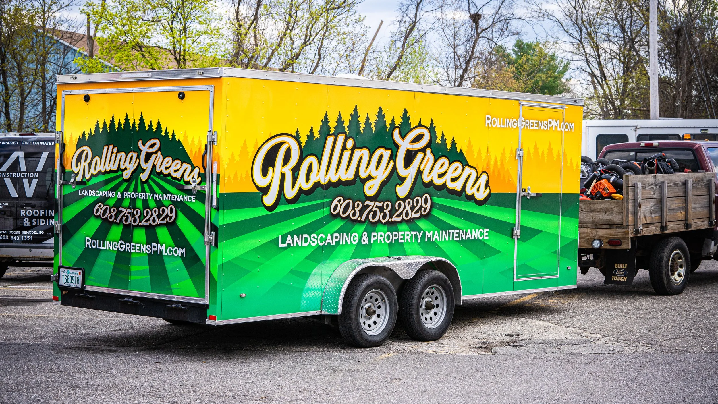 Colorful gardening and property maintenance trailer with green, yellow, and orange graphics, and the company name 'Rolling Greens' along with contact information and website URL.