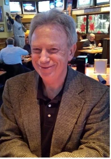 Middle aged man with plaid blazer and sport shirt, smiling
