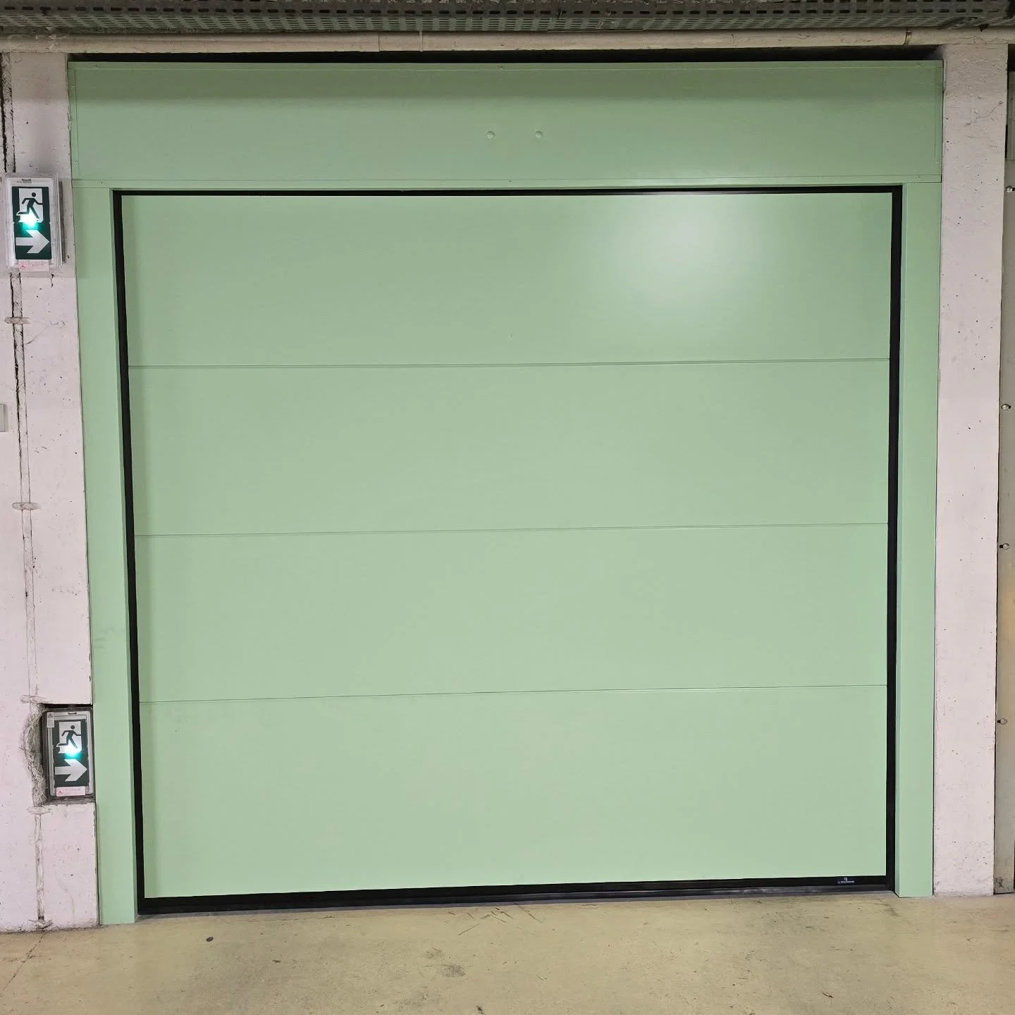 Pose d'une porte sectionnelle motoris&eacute;e en remplacement d'une porte basculante.