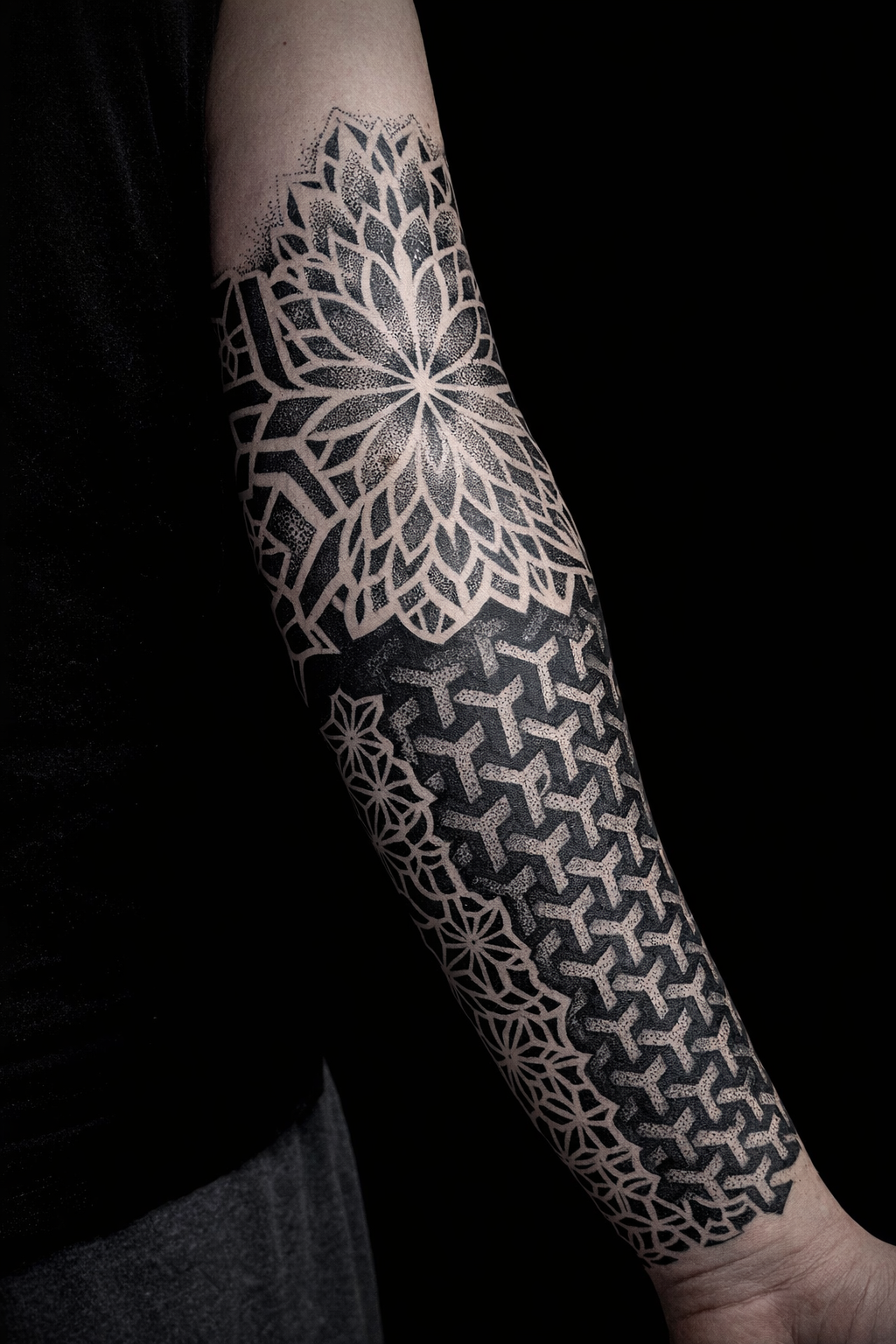 A person's arm with a black and white geometric tattoo extending from the shoulder to the wrist.