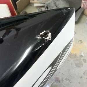 Scratched and damaged black and white surface on a vehicle or equipment.