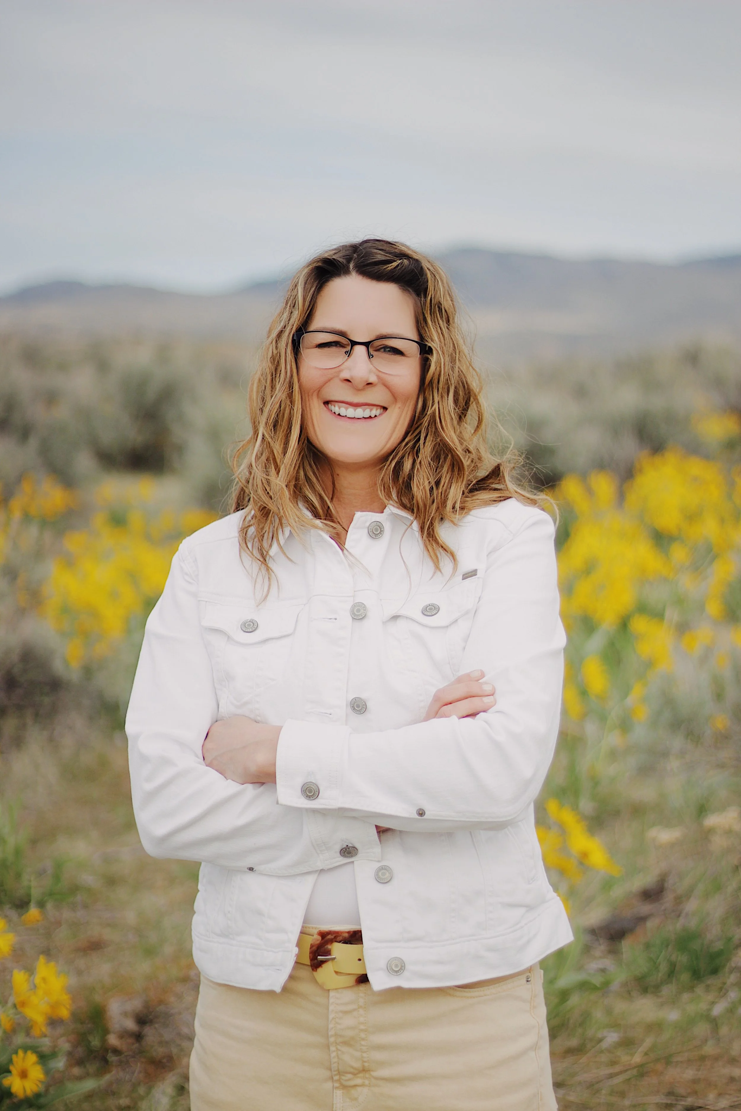 Michelle Batten trauma therapist Boise Idaho smiling confidently in yellow wildflower field