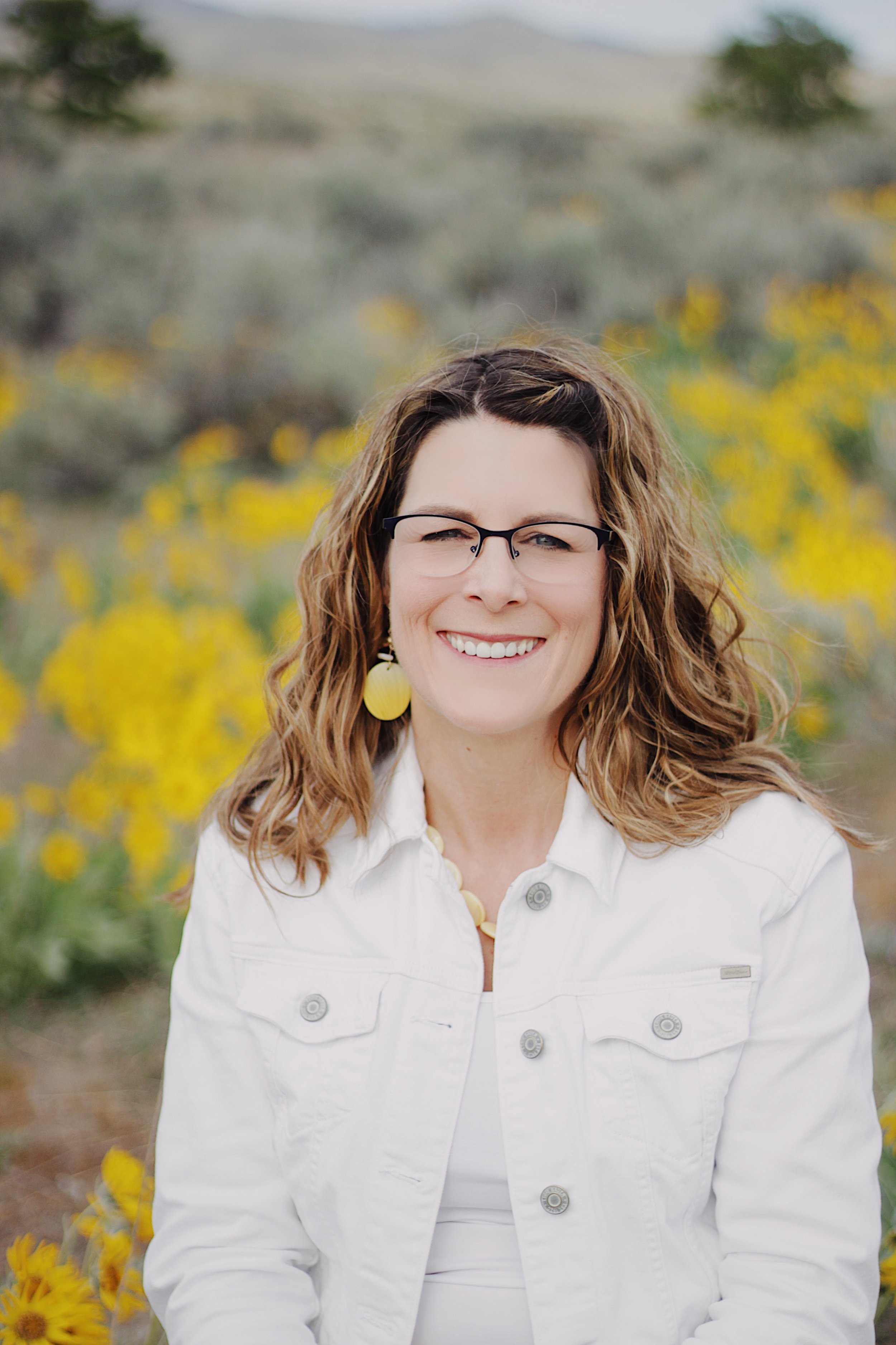Michelle Batten Licensed Professional Counselor smiling in yellow wildflower field Boise Idaho