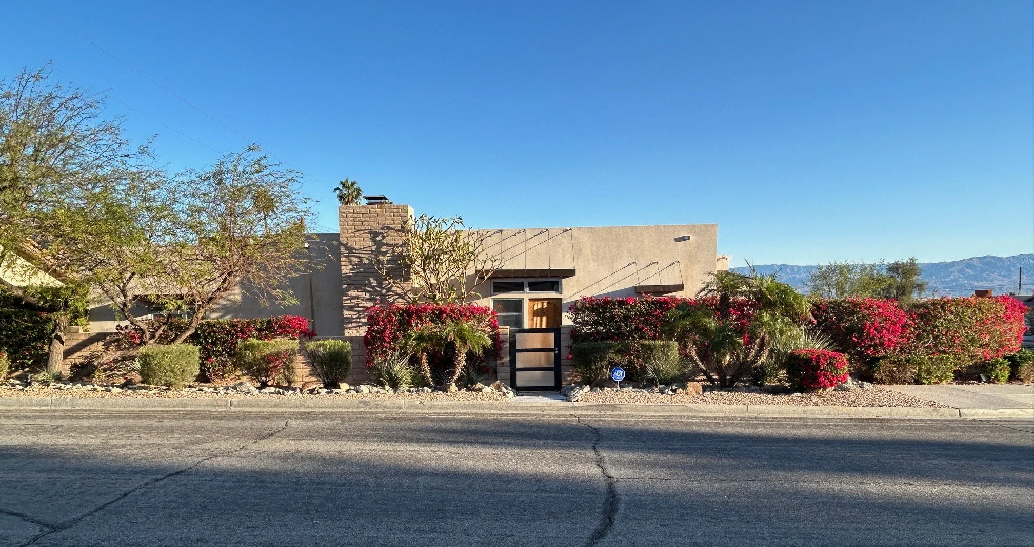 Eisenhower Private Compound exterior with gated entry, desert landscaping and mountain backdrop