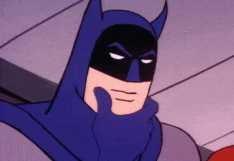 Close-up of Batman with a thoughtful expression, hand on chin, in animated style.
