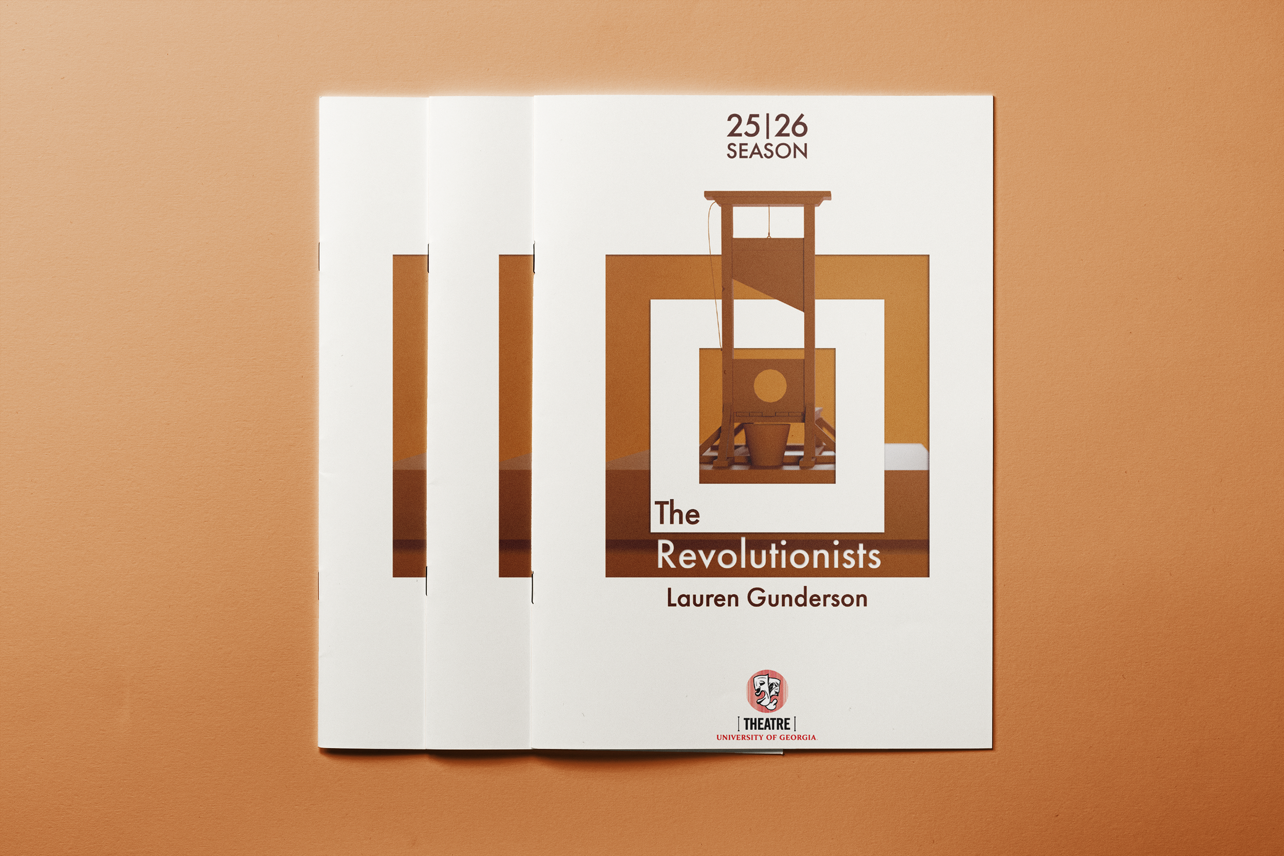A booklet titled 'The Revolutionary Spirit: 25/26 Season' by Lauren Gunderson, placed on a warm, peach-colored surface. The booklet features a modern graphic design with brown and white colors, depicting a stylized ancient device or rocket. The logo of the University of Georgia Theatre is visible at the bottom.