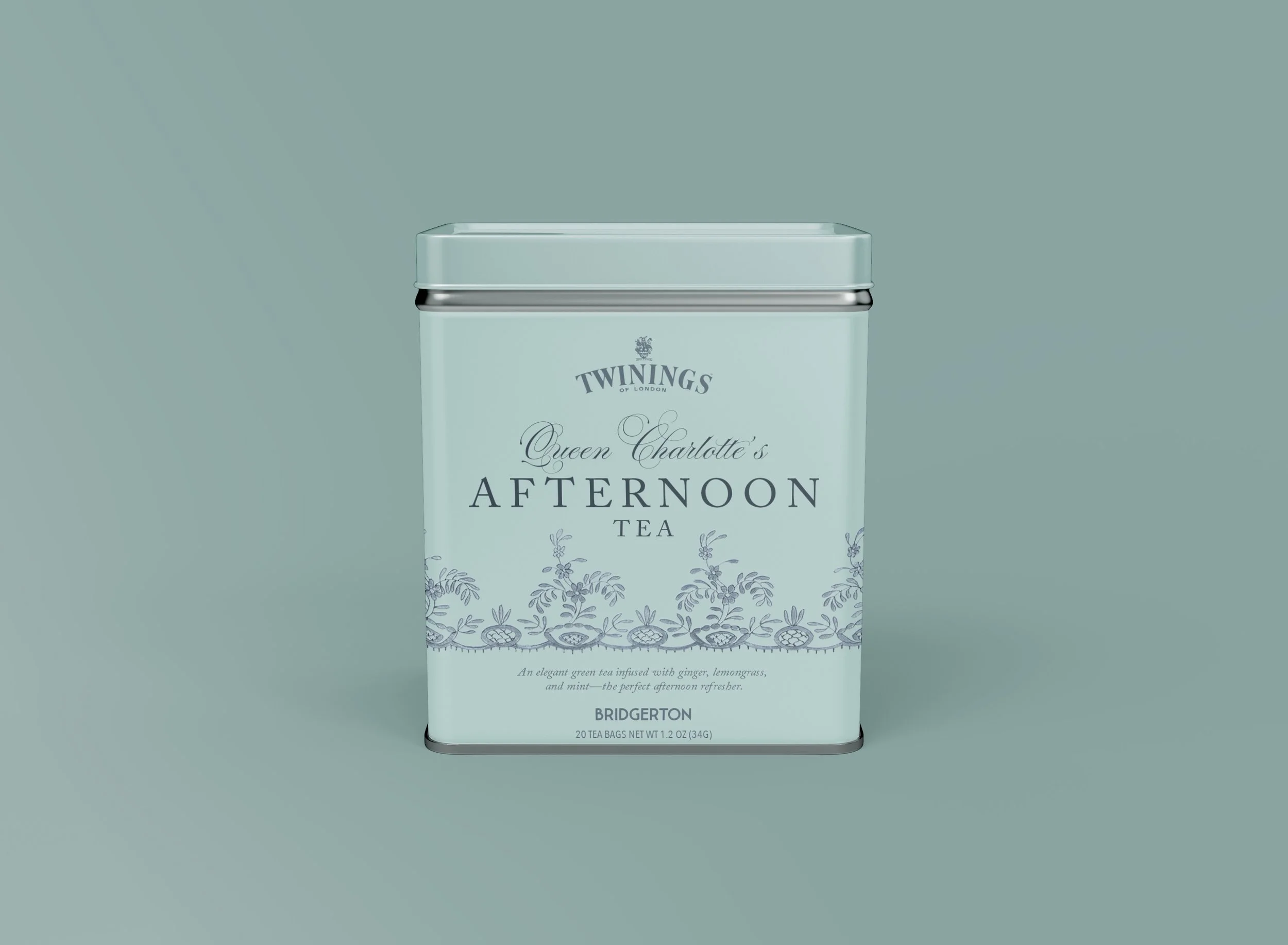A rectangular, light teal tin container with a silver rim and lid, featuring branding for Twinings Queen Charlotte's Afternoon Tea, with a decorative floral pattern and product description at the bottom.