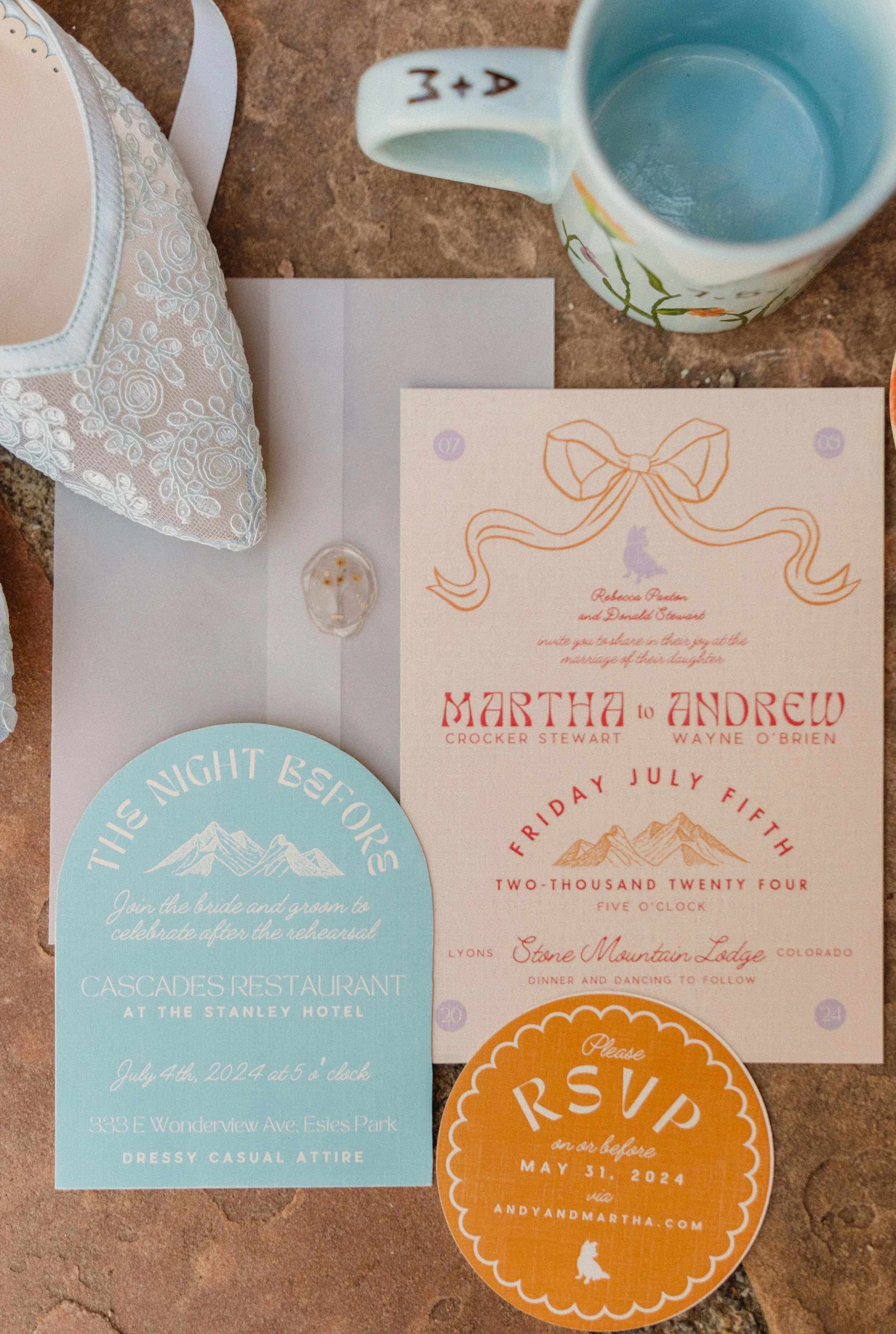 Wedding invitation cards and event RSVP card on a brick surface, including details for a wedding celebration and reception.