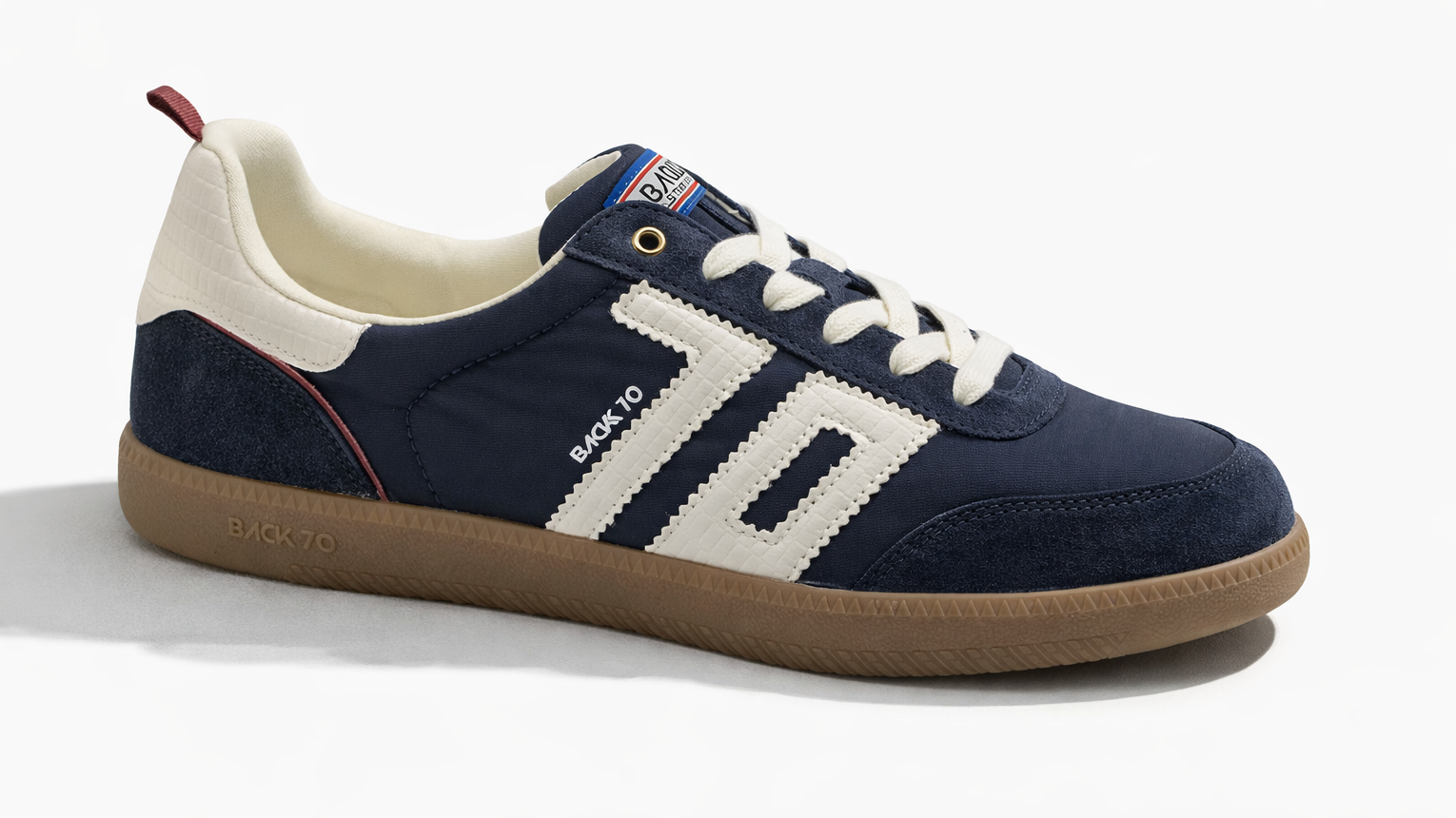 A navy blue sneaker with white accents, beige sole, and red details, labeled 'BACK 10' and 'BACK 70' on the side.