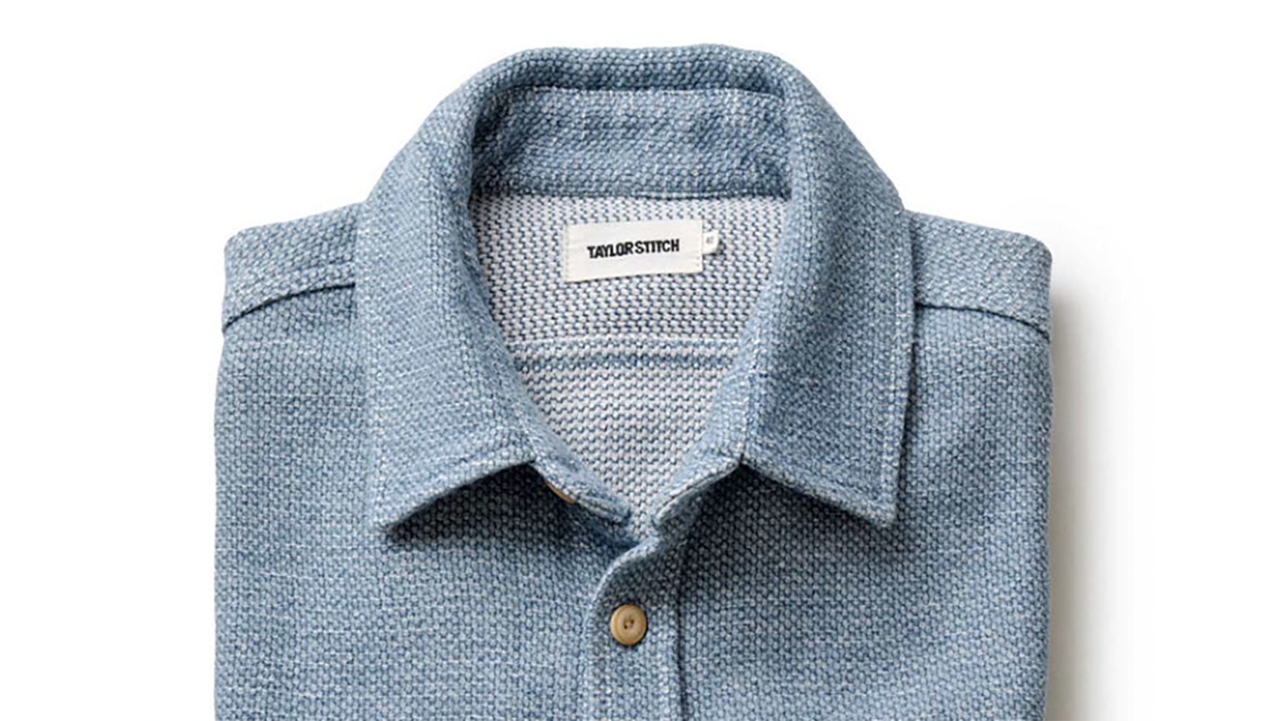 Folded light blue patterned dress shirt with a label that reads 'TAYLOR STITCH'.