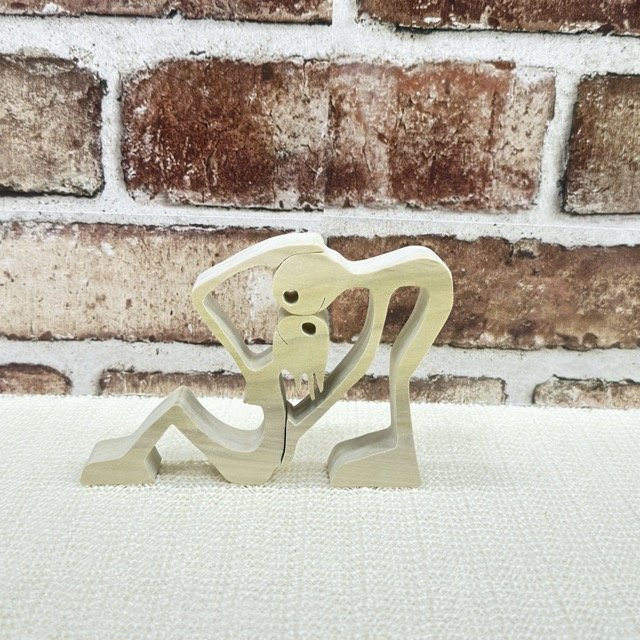 minimalist handcrafted wooden sculpture of two interlocking figures in an embrace, showcasing the custom artistic woodworking of Bearclaw Woodfixins
