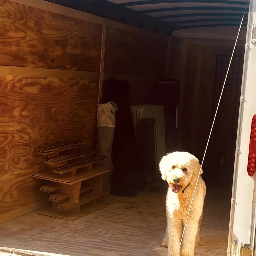 Loading handcrafted wood puzzles and preparing for an event, while our golden doodle shop dog supervises for  Bearclaw Woodfixins