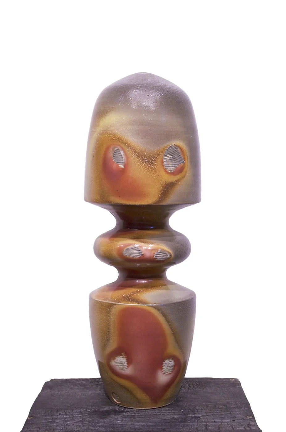 A multicolored abstract ceramic sculpture with a smooth, rounded top, a middle section with three smaller rounded shapes, and a wider base, displayed on a dark wooden platform against a plain white background.