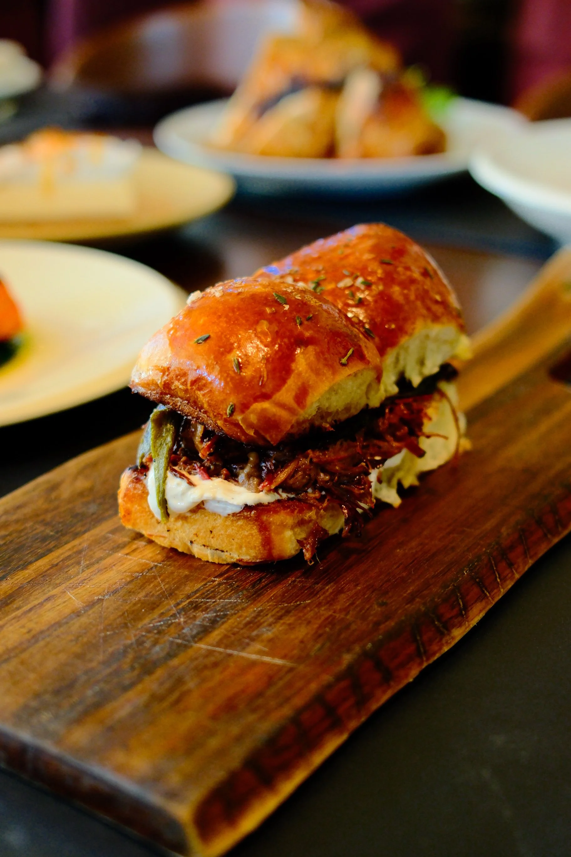 Pork sliders on a wooden serving tray