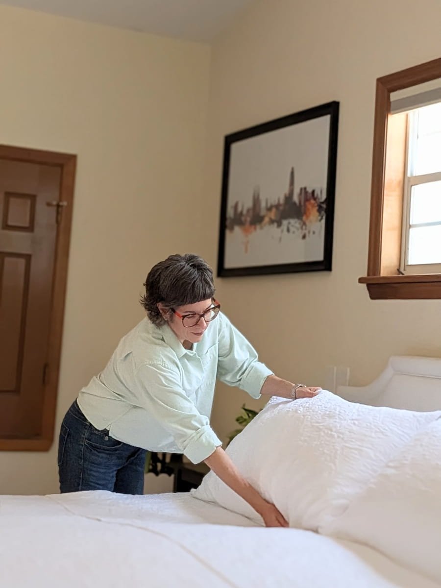 Lighter Home founder Colleen Raccioppi changing bed linens in a Gainesville Florida home — weekly linen changes included in household management retainer.