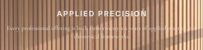 Text overlay on a background of wooden vertical slats, reading 'APPLIED PRECISION' and 'Every professional offering is built from twenty-six years of applied scientific and theoretical frameworks.'