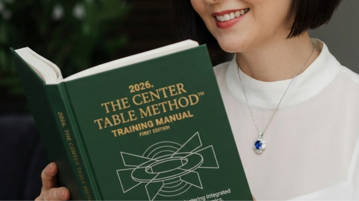 A smiling woman holding a green book titled '2024. The Center Table Method Training Manual'. She is wearing a white top and a silver necklace with a blue gemstone pendant.