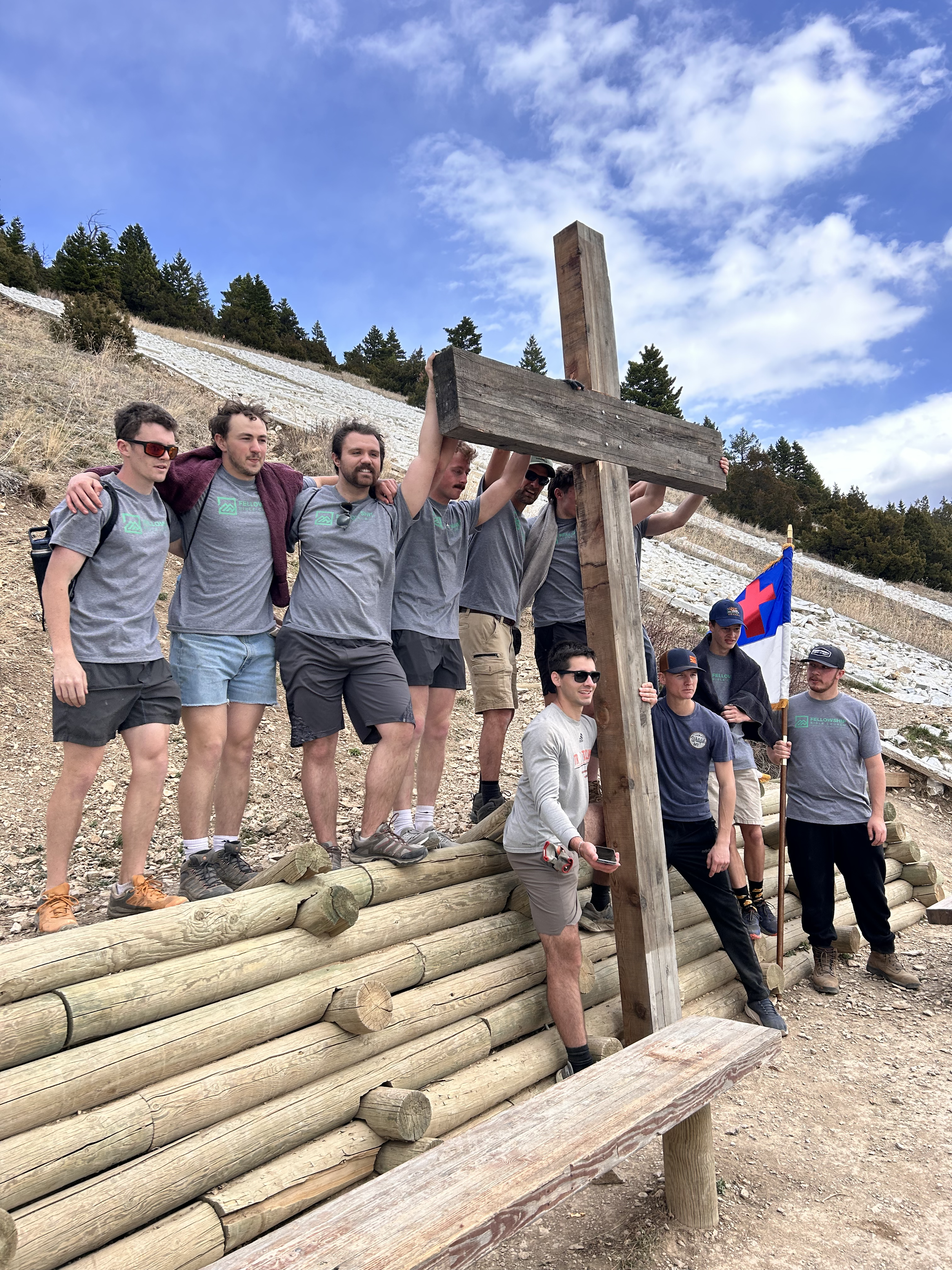 Group holding cross on a hike
