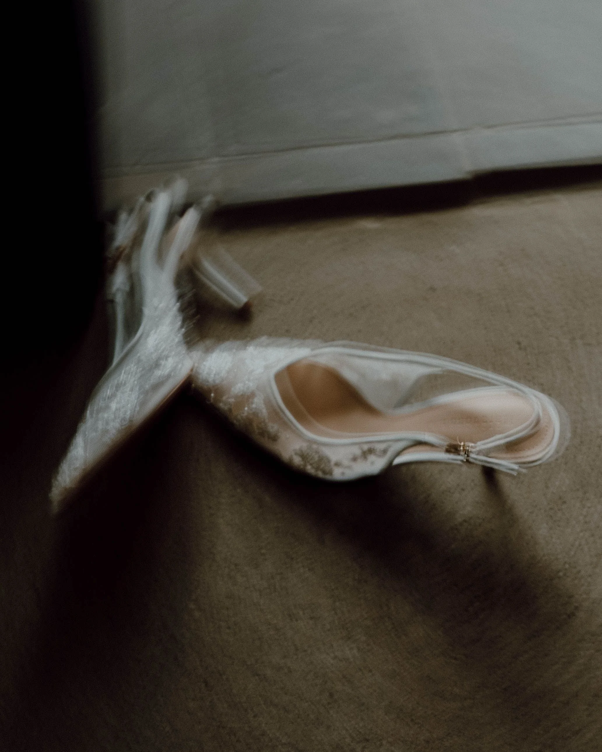 Close-up view of a white electric cord connected to an appliance, with a beige surface and part of a floor visible.