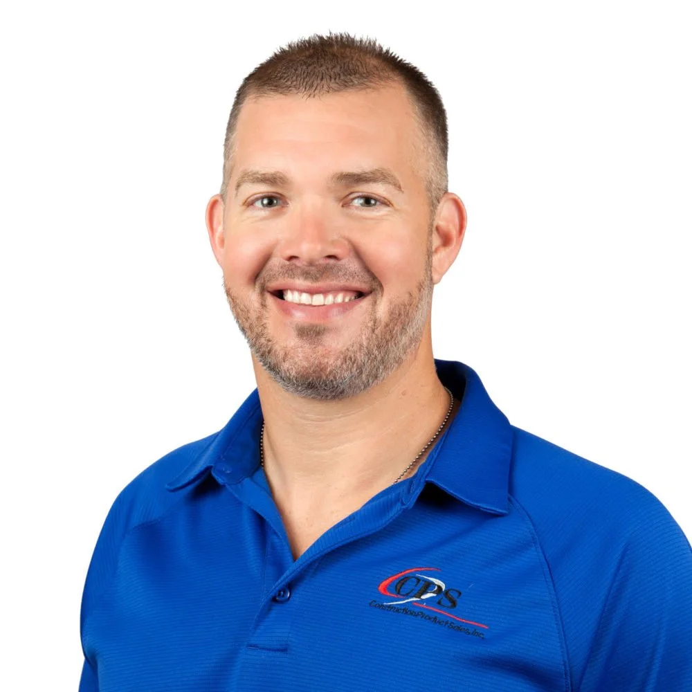 Headshot of a man smiling, wearing a blue collared shirt with a logo that says 'Connect Your Dots'.