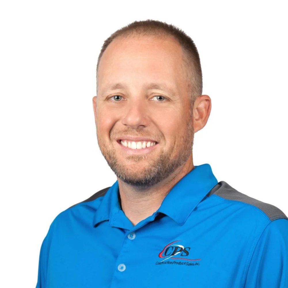 A smiling man wearing a blue polo shirt with construction company logo, posing against a white background.