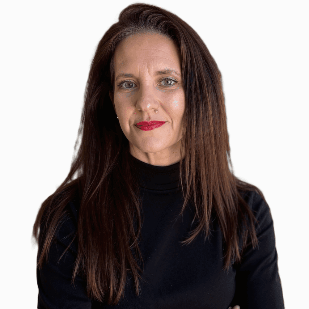 A woman with long brown hair, wearing a black turtleneck, looking at the camera with a slight smile, red lipstick, and a white background.