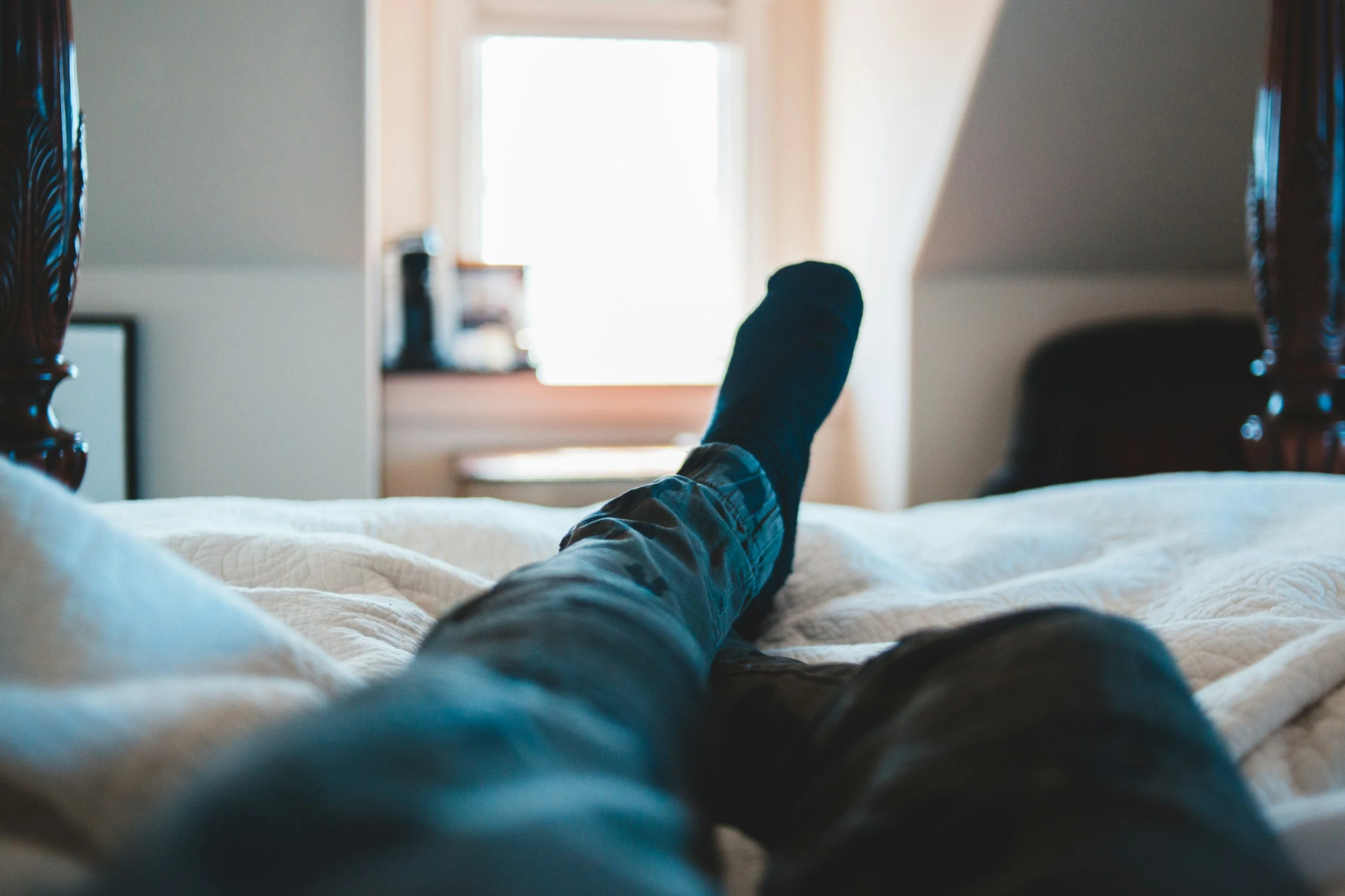 homme assis sur son lit, routine du soir pour pieds secs