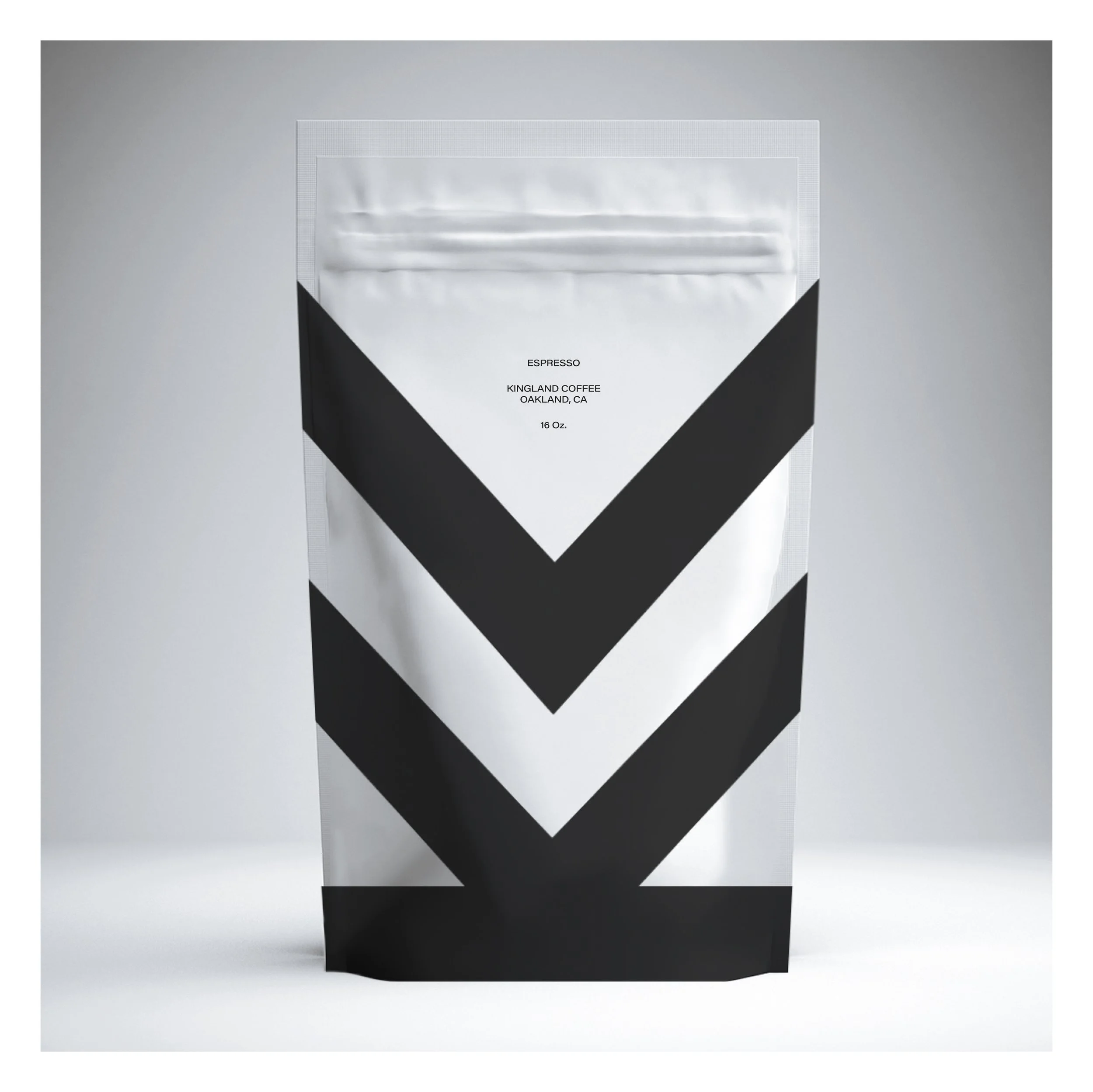 A modern, minimalistic black and white paper bag with the label 'ESPRESSO KINGLAND COFFEE OAKLAND, CA 16 Oz.' on the front, set against a plain gray background.