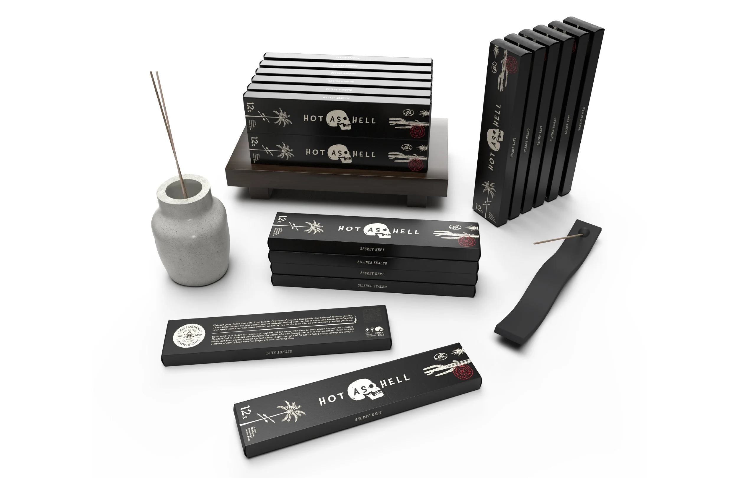 Photo of black and gray boxes labeled 'Hot As Hell' with palm trees and skull graphics, incense sticks in a gray vase, and incense boxes on a white background.
